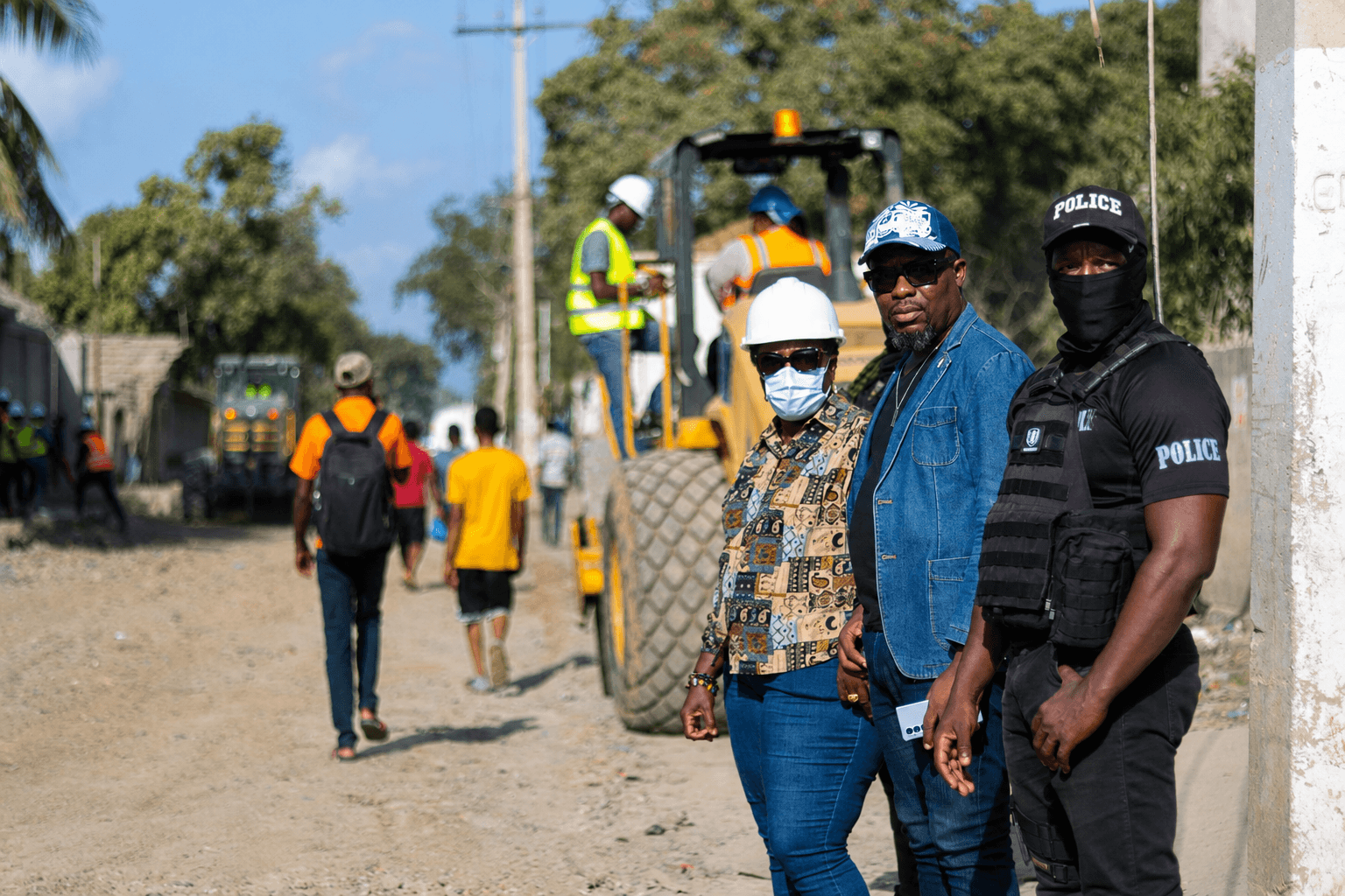 Yvrose Pierre portant un casque pendant une visite de terrain avec des responsables locaux